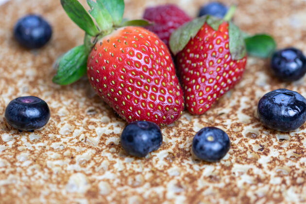 装饰性成熟多汁的草莓和蓝莓躺在美味的煎饼上俄罗斯料理国家菜 带新鲜浆果有机水果烹饪