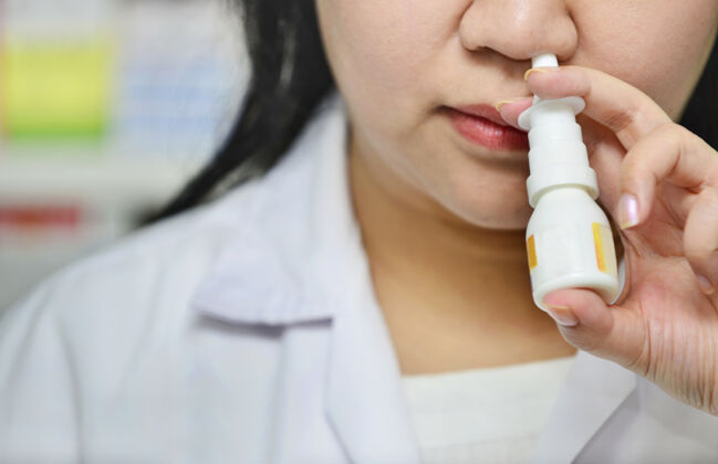 鼻子一名年轻女子在医院使用鼻喷雾剂药物的特写镜头药店.季节性健康问题生病呼吸器过敏