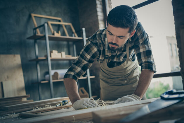 木板低视角下严肃自信体贴专注的男人专注于用砂纸打磨木框Diy设计师装修