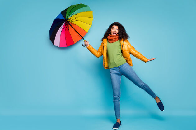 多国深色皮肤的女士手持飞天蓝色背景彩虹色阳伞非洲雨伞女性