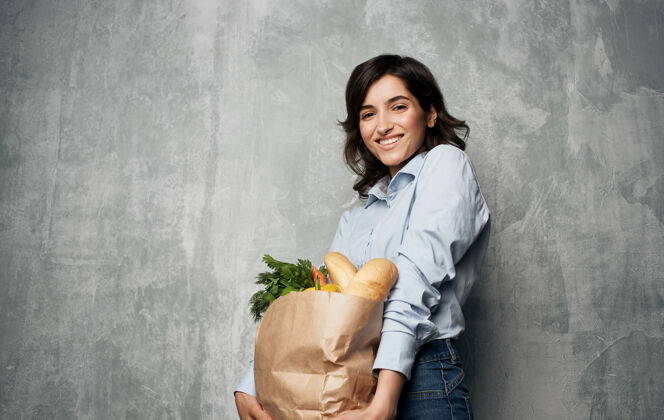持有开朗的女人从健康食品包装超市送货购物消费主义填充微笑