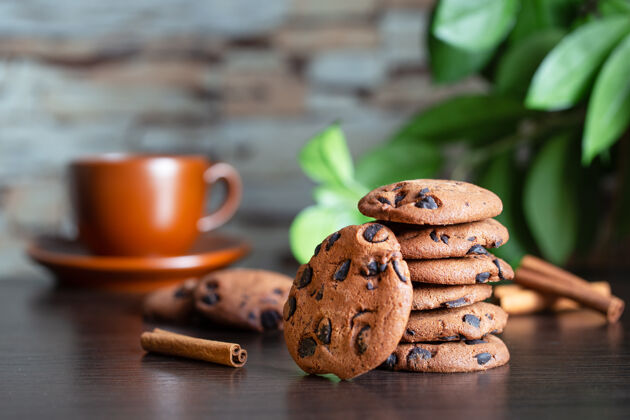 木头在一杯咖啡和绿色的背景下 桌上放着巧克力燕麦片饼干树叶早餐或者早上喝咖啡堆栈饮食薯片