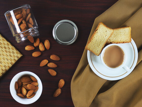 食物在一张深色的木桌上放一杯茶 上面放着拉斯克饼干和杏仁脆俄罗斯美味