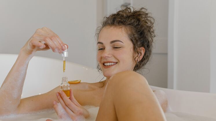 房子在浴缸里用橘子片洗澡的女人沐浴泡沫自我护理精华液