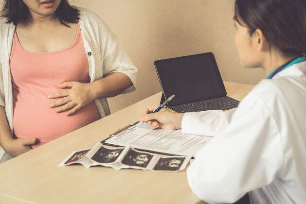 诊所快乐的孕妇到医院或诊所找妇科医生做妊娠顾问医生医院药片