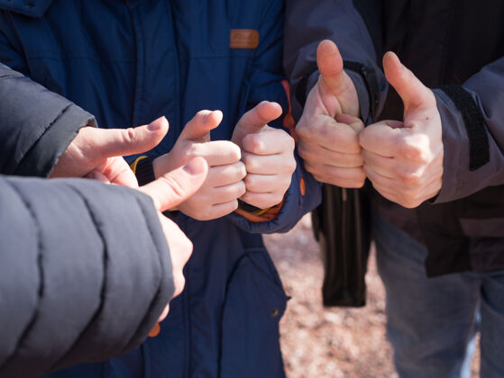 表演孩子和两个男人竖起大拇指 团队概念团队合作大拇指积极