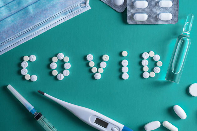 检疫铭文“covid” 由白色圆形一次性药片注射器和小瓶上的药物呈红色背景.covid-19冠状病毒疫苗空间为文本胶囊白色字母