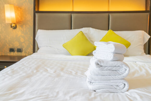 室内白色毛巾折叠在酒店度假床上客房酒店服务