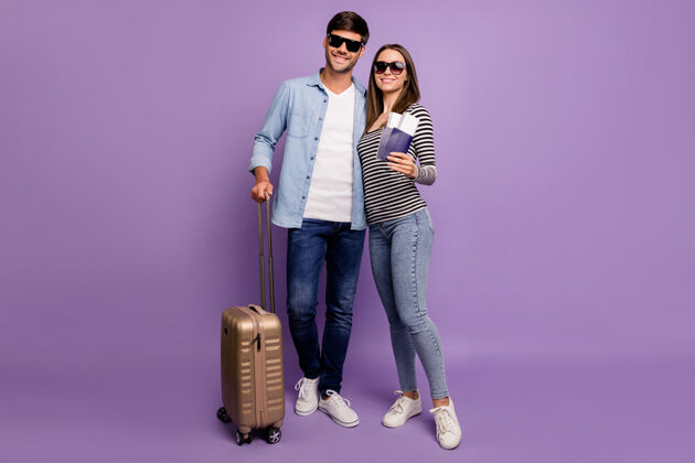 朋友全长两人情侣盖伊女士步行机场登记机票护照行李度假时间穿时尚休闲服隔离粉彩紫色墙壁眼镜情人牛仔裤