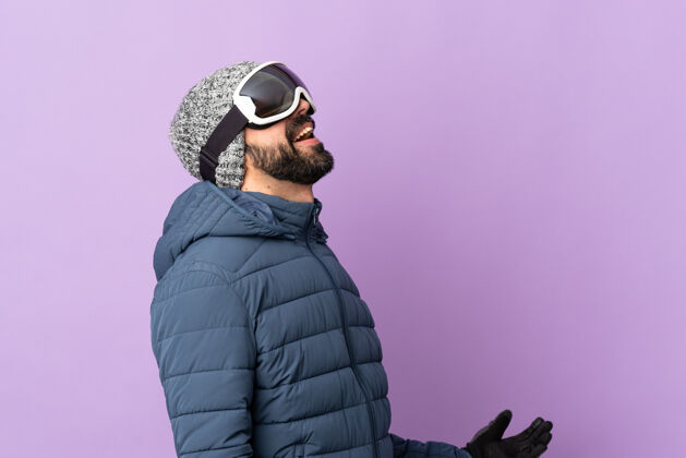 人带着滑雪眼镜的滑雪者越过隔离的紫色墙壁冬天肖像成人