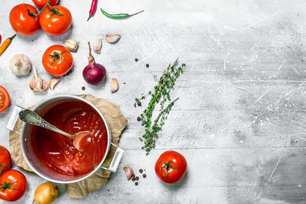 顶视图一壶香草番茄酱和新鲜番茄放在乡村餐桌上辣椒健康纸张