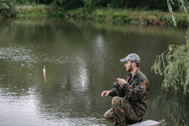 渔民一个渔夫拿着鱼竿在河岸上水自然成人