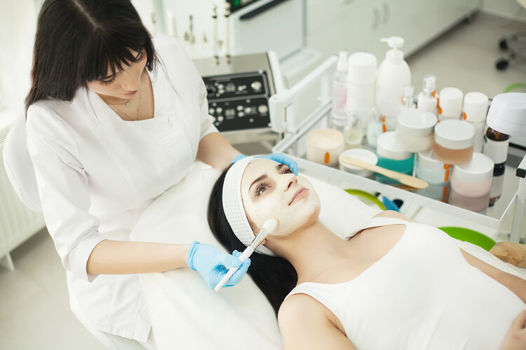 面部美容师在美容室给客户涂面霜美容师Spa女人