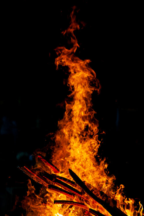 温暖在黑暗背景下燃烧的篝火 燃烧着木头的火焰营火灰烬烟