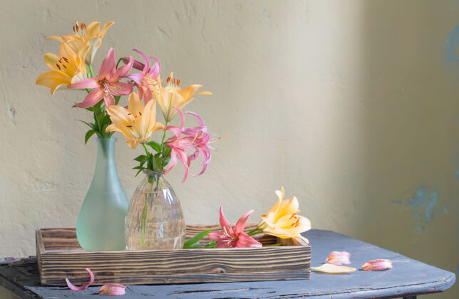棕色美丽的百合花在旧木架上的玻璃花瓶里充满活力花园七月