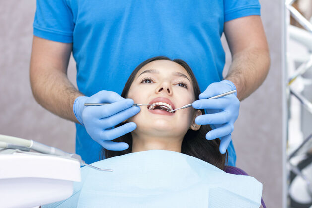 医院牙科医生和病人办公室女职员让牙医检查牙齿工具正畸快乐