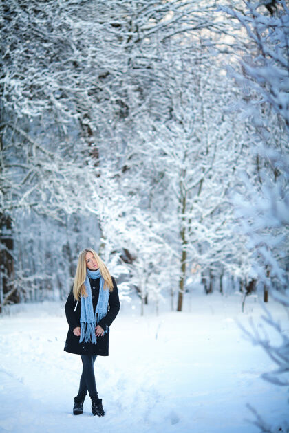 自然美丽的金发少女漫步在冬日的森林里可爱欢呼毛衣