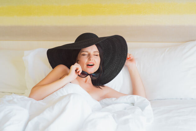 房子一个戴着大帽子和太阳镜的小女孩躺在床上航行女性卧室