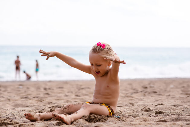 生活方式小女孩在海边的沙滩上玩戒指海滩明亮