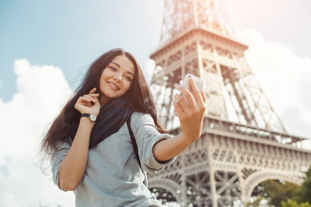 自拍巴黎埃菲尔铁塔附近 快乐旅行的女人拿着她的手机自拍风景欢乐肖像