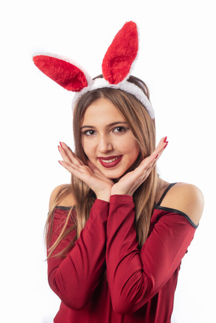 圣诞老人戴着兔子饰物的美女在白色上摆姿势女性可爱欢呼