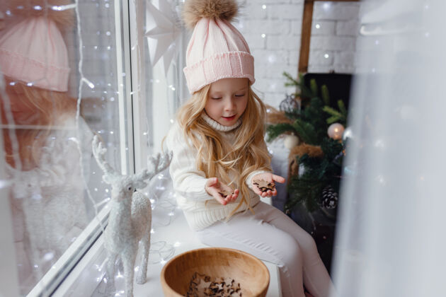 房间圣诞节早晨坐在窗台上的小女孩舒适快乐室内