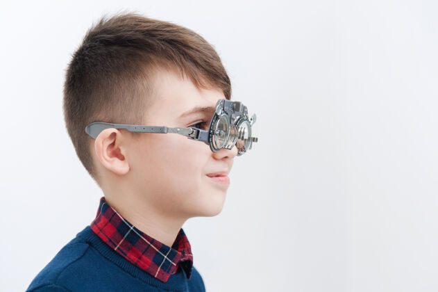 视力一个戴眼镜的男孩在眼科医生那里检查视力仪器测试眼科