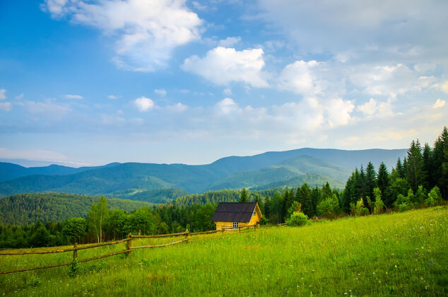 草在山上 山坡上是一座绿色草地上的小房子自然房子天际线