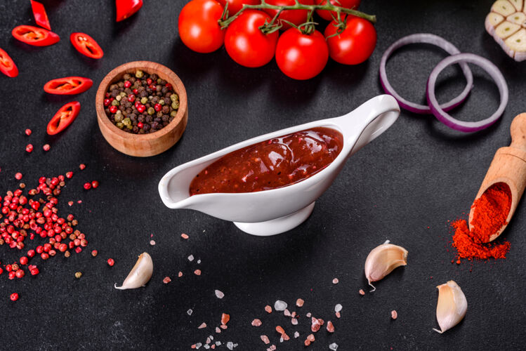 红色格鲁吉亚菜的辛辣调味料阿吉卡在一个碗里 用红辣椒和大蒜放在混凝土桌上特写镜头美味热蔬菜