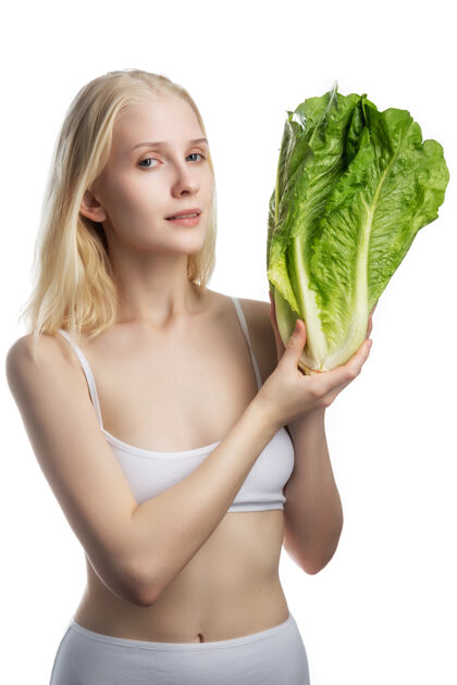午餐年轻的女人拿着一大捆新鲜的莴苣.绿色手中的沙拉叶女人健康干净的饮食概念素食主义者 素食者食品.复印件空间健康蔬菜维生素