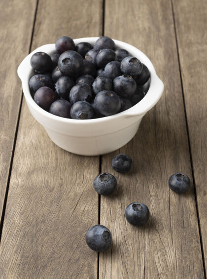 纤维木桌上的碗里放着蓝莓甜点成熟的食品