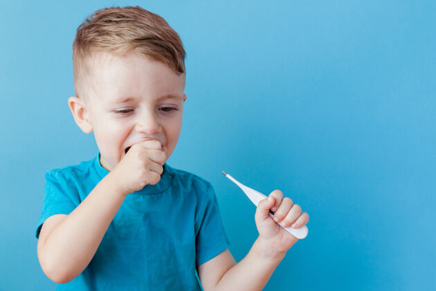 测量一个生病的小孩拿着一个吸热剂 量着他发烧的高度 看着镜头肖像温度手