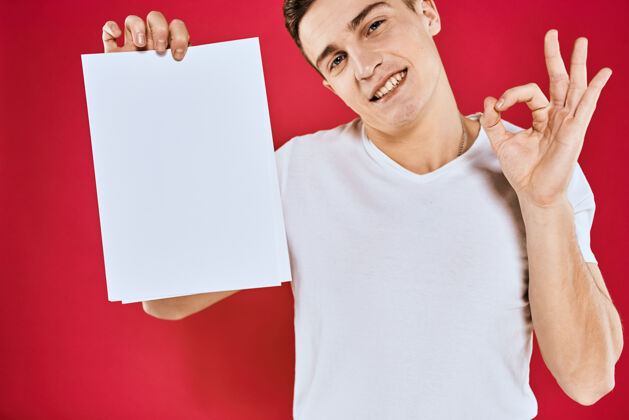 肖像情绪激动的男人拿着一张纸复印空间t恤红色站广告牌年轻