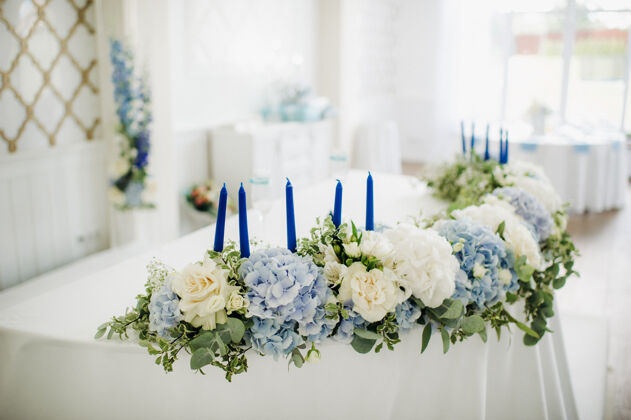 玫瑰婚宴桌上装饰着蓝色的鲜花 在餐厅的餐桌上装饰着婚礼的晚餐婚礼晚餐鲜花