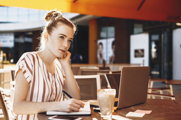 杯子迷人的年轻商务女性 红发雀斑 在咖啡店喝咖啡时做笔记女人电脑网络