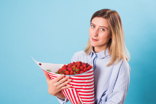 礼品拿着一束草莓的年轻女人光明素食草莓