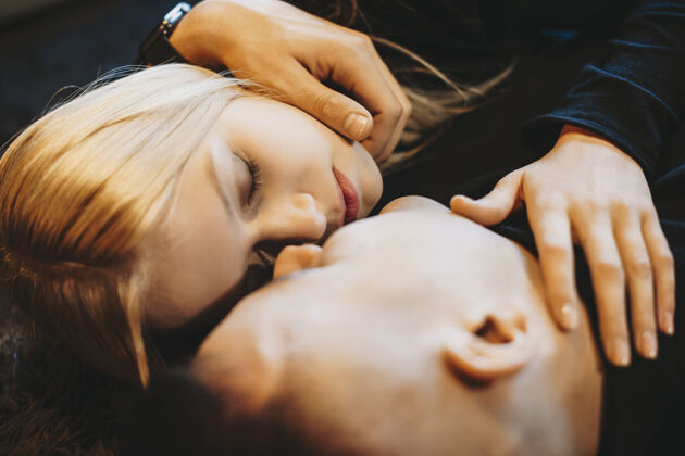 浪漫一对可爱的年轻夫妇在亲吻前紧闭双眼靠在地板上的特写照片妻子年轻情人节