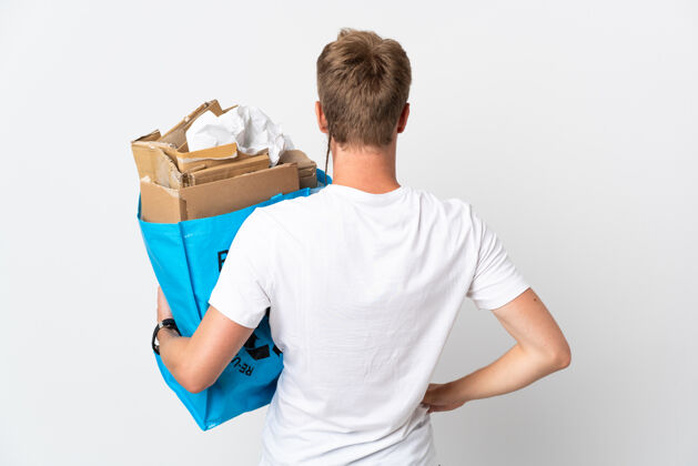 男性年轻的金发男子拿着一个回收袋 里面装满了回收纸 把白色隔离在后面的位置志愿者环境青年