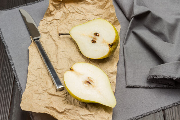 营养纸上的两份梨和灰色餐巾刀柑橘餐巾纸