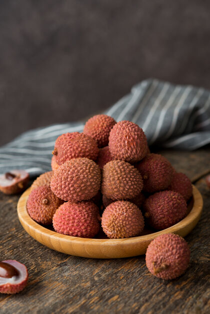 亚洲成熟的荔枝浆果放在木桌上的盘子里水果甜点甜