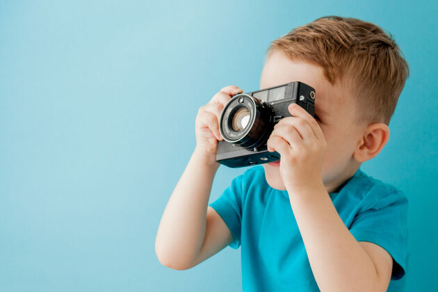 孩子小男孩拿着一架蓝色的旧相机小甜蜜人