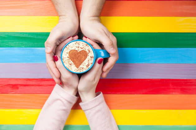 卡布奇诺女人和男人拿着一杯咖啡 颜色表面有心形符号咖啡馆早晨饮料