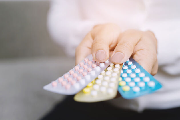 药物近距离观察妇女手持避孕药避孕的概念方法生育保护药剂师