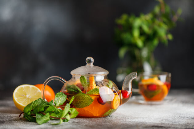 桑格里亚水果茶配薄荷 橙子和红莓 背景为深色石头一杯热茶饮料维生素草药