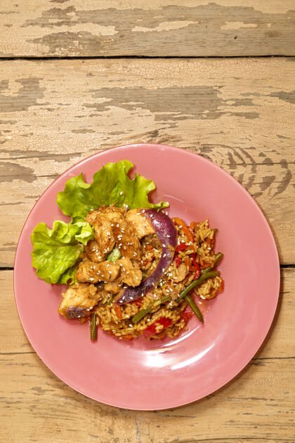 混合在一个盘子里的木桌上 蔬菜 米饭 鸡肉 沙拉叶上的芝麻胡椒红辣椒菲力