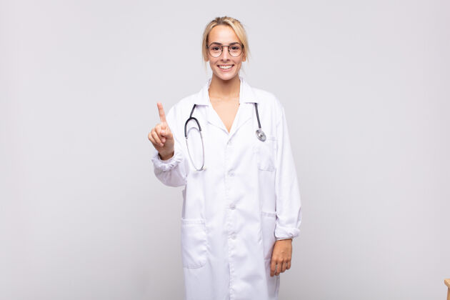 肖像年轻的女医生面带微笑 面带友好的神情 一号或一号手向前伸 倒数成人诊所医学