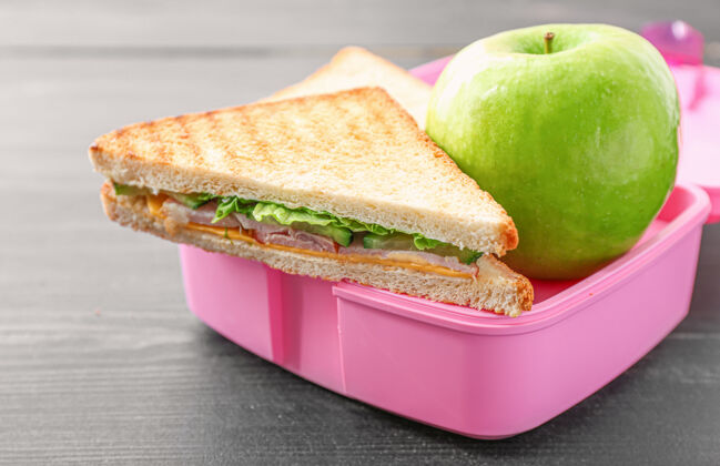 午餐时间学校的饭盒上有好吃的食物水果零食苹果
