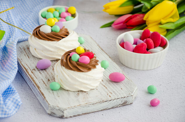 部分迷你巴甫洛娃鸟巢巧克力奶油和彩色糖果烘焙孩子糖果