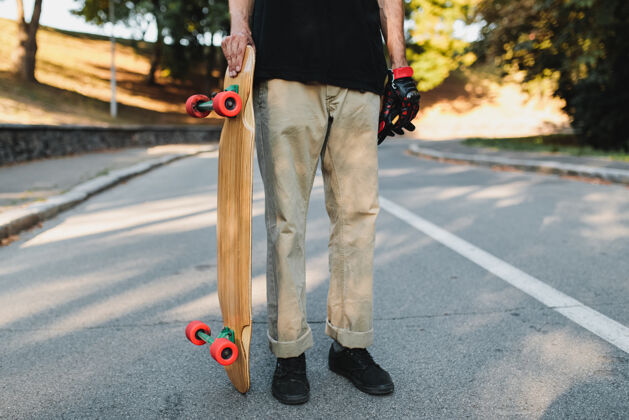 街道那家伙拿着一块红色的木板轮子滑板在永恒中城市高中高质量的照片青少年滑板滑板