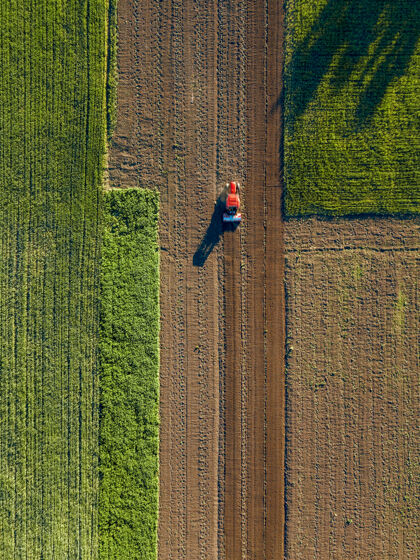 草地农田拖拉机鸟瞰图播种机 拖拉机在农业领域工作春天照片用无人机环境保护乡村田野